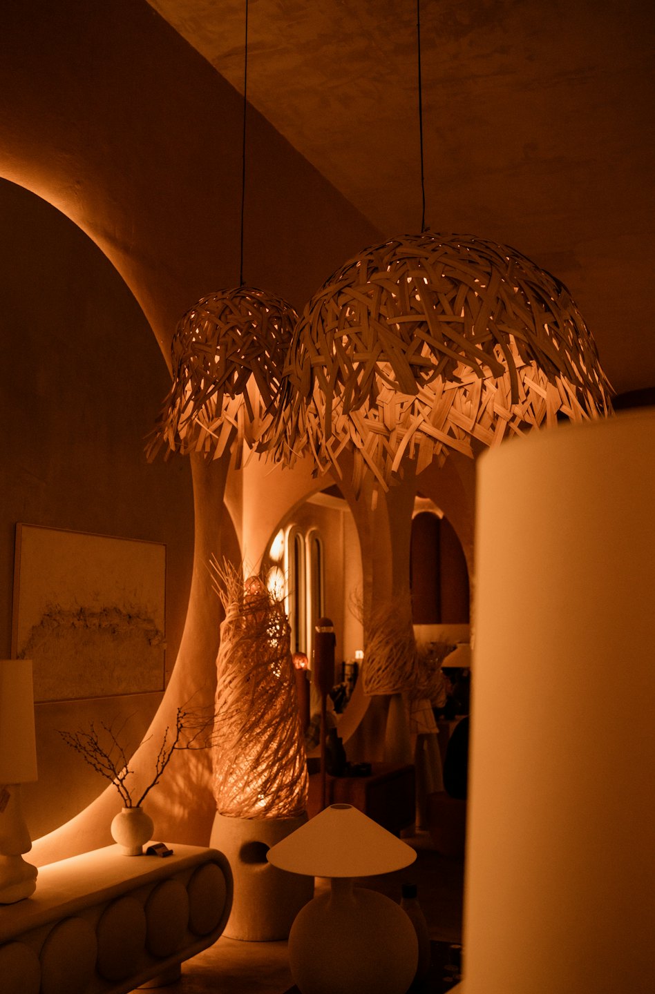 Two large woven pendant lamps hang above a modern table.